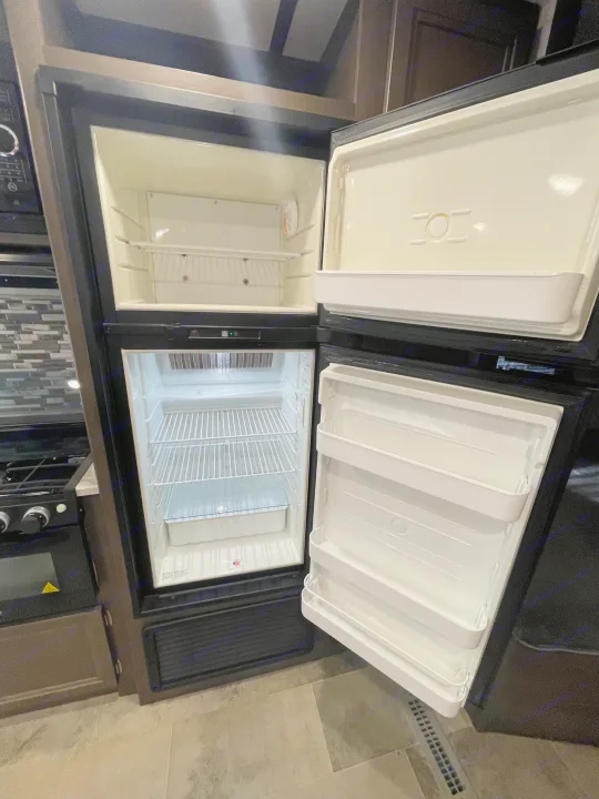 Empty two-door RV rental refrigerator in a clean RV kitchen, ready for your food on the go.. Coleman 262BH 2021