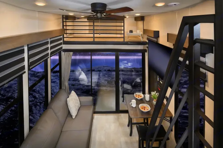 This RV rental offers a compact living area with a loft, sofa, dining space, and expansive windows.. Forest River Timberwolf 16ML 2024