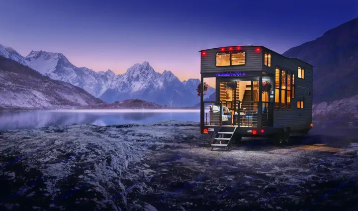 Modern rv rental, an illuminated tiny home, by a misty lake with snow-capped mountains at twilight.. Forest River Timberwolf 16ML 2024