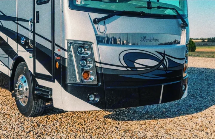 Front view of a sleek Berkshire RV rental parked on gravel, ready for adventure.. Forest River Berkshire 2023