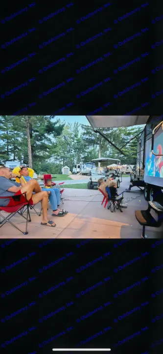 An outdoor movie night with family and friends, featuring a film projected onto an RV rental at a spacious campground.. Gulf Stream Conquest 2016