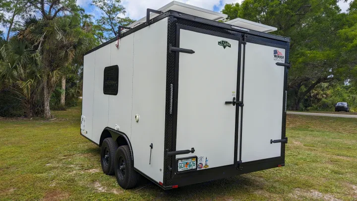 White cargo trailer RV rental conversion with solar panels & rear doors, ready for your adventure.. Diamond Cargo 16x8.5 2023