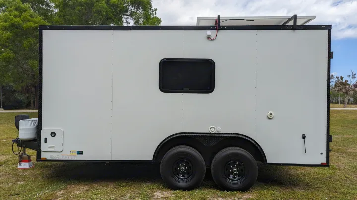 White cargo trailer RV conversion with solar, window, & amenities. Consider for rv rental.. Diamond Cargo 16x8.5 2023