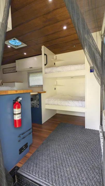 Spacious RV rental interior with custom bunk beds, wood ceiling, and cozy sleeping areas, perfect for adventure.. Diamond Cargo 16x8.5 2023