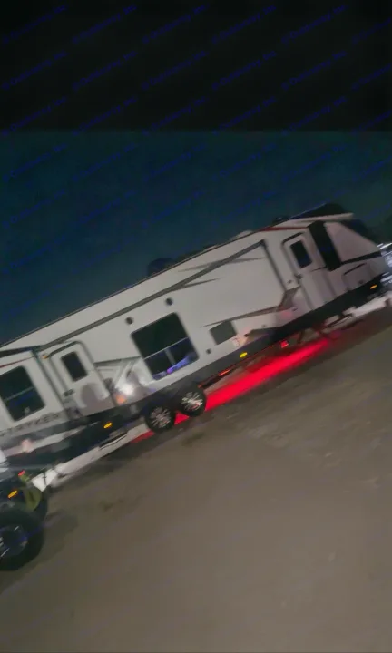 A large white Stryker RV rental, a travel trailer with red underglow lights, is parked at night.. Cruiser Rv Corp Stryker 2021