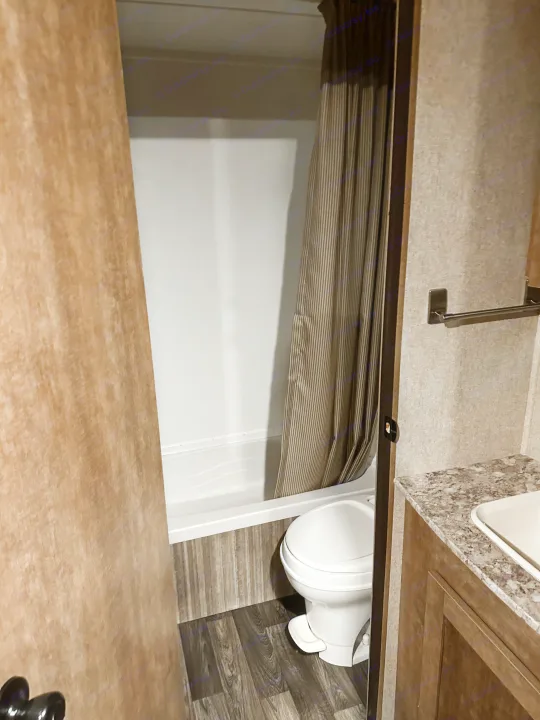 RV rental bathroom: compact space featuring a toilet, a shower/tub combo with a striped curtain, and a sink vanity.. Starcraft AR-One Maxx 2017
