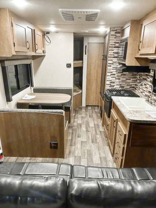 Inside an RV rental, discover a bright kitchen, dinette area, and bunk beds, with wood-look flooring.. Starcraft AR-One Maxx 2017