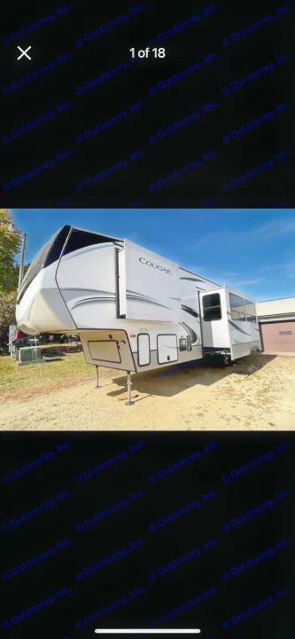 White Cougar fifth-wheel RV rental with slide-outs extended, parked outdoors on a clear day.. Keystone RV Cougar 2021