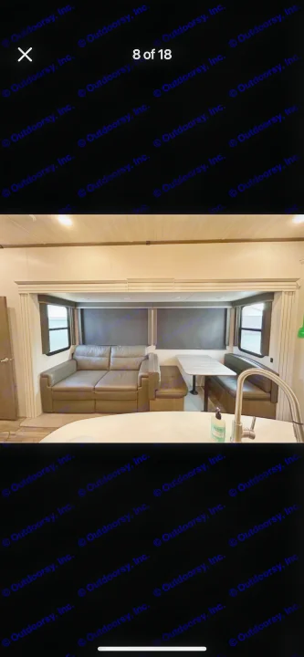 RV rental: Spacious interior with a comfortable sofa, dinette booth, and a kitchen counter. Windows provide light.. Keystone RV Cougar 2021