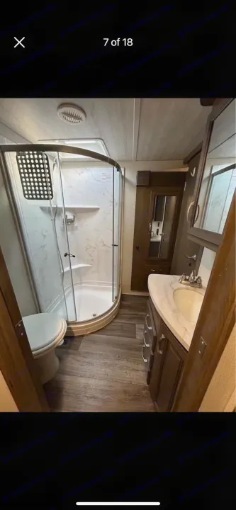 RV rental: a compact yet complete bathroom with corner shower, toilet, and modern vanity.. Keystone RV Cougar 2021
