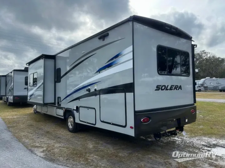 Grey Solera motorhome for rv rental, with blue decals, parked in a lot with other RVs under a cloudy sky.. Forest River Solera 2024