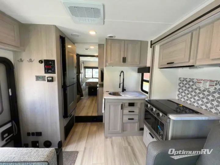 Spacious, modern rv rental interior with bright kitchen (sink, stove, fridge) and bedroom. Explore amenities!. Forest River Solera 2024