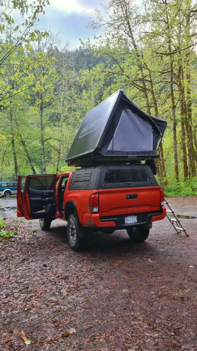 Orange Toyota Tacoma with rooftop tent set up for camping, an ideal alternative to an RV rental for outdoor adventure.. Toyota Tacoma TRD OFF ROAD 2018
