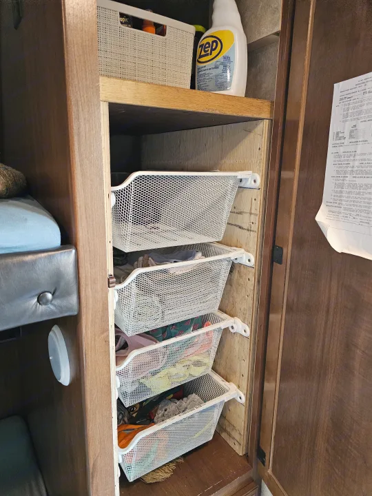 RV rental cabinet with mesh pull-out storage for clothes and cleaning supplies, maximizing space.. Jayco X213 2016