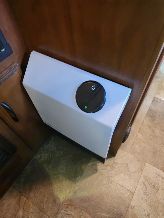 Heat Storm portable heater with green light, providing comfort in an RV rental. Visible on the floor against wood paneling.. Jayco X213 2016
