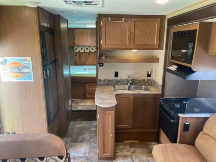 Tour this RV rental's kitchen and living area, complete with refrigerator, microwave, stove, and sink.. Coachmen Leprechaun 2017