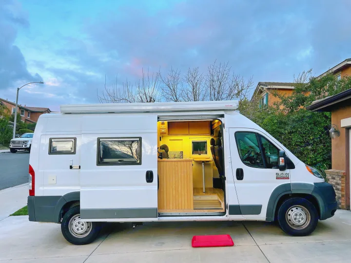 White Ram ProMaster rv rental, a custom camper van with illuminated wood interior, parked at dusk. Ready for adventure!. Ram promaster 2500 2017