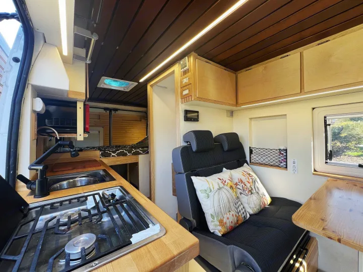 Inside a well-equipped rv rental: this camper van boasts a full kitchen, comfy seating, and built-in bed for travels.. Ram promaster 2500 2017