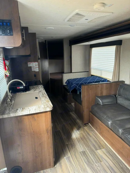 Inside a modern **rv rental**: well-equipped kitchen, cozy dinette, and comfortable sofa, perfect for your travel adventures.. Shasta 26db 2020
