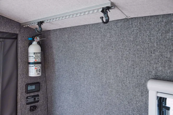 An RV rental interior with a fire extinguisher, Renogy controls, and a versatile ceiling track for storage.. Gmc sierra 1500 2024