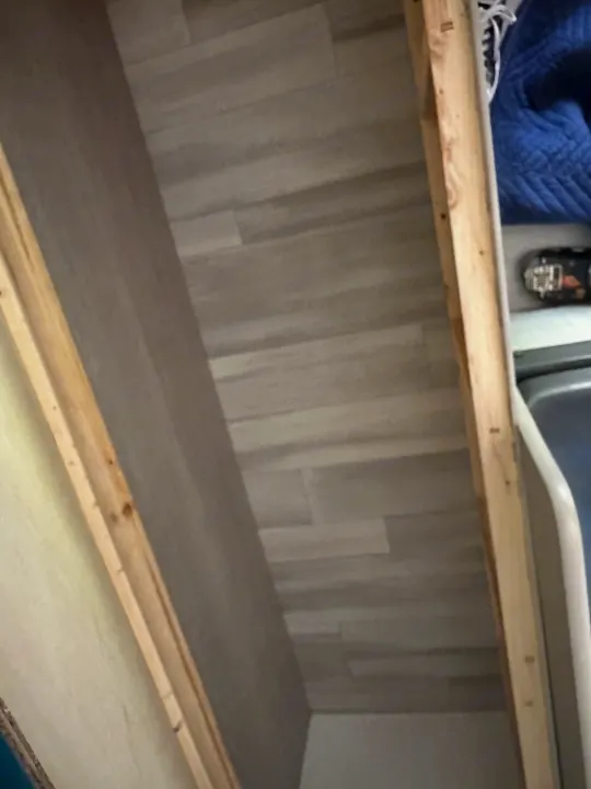 RV rental interior: A utility or storage space featuring light plank flooring, wooden framing, and a partial appliance.. Keystone RV Springdale 2024