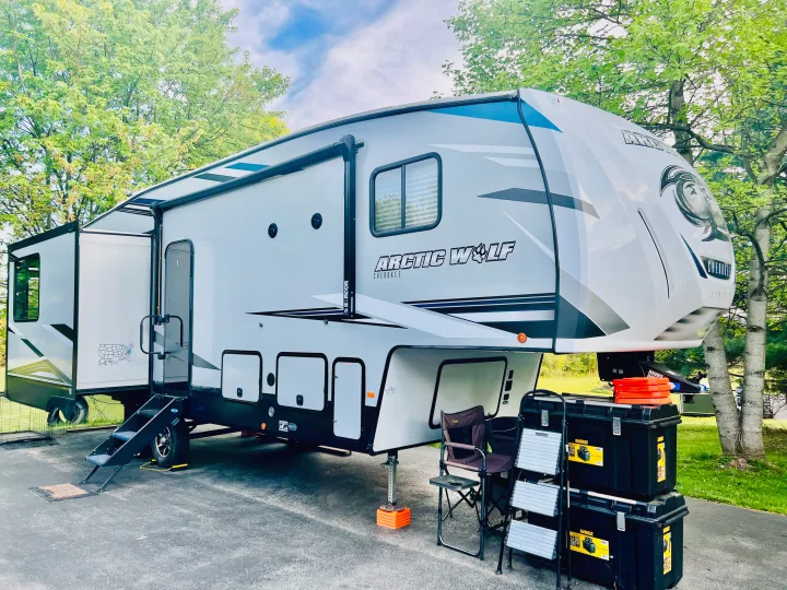 Large white/grey Arctic Wolf fifth-wheel RV rental parked with gear for outdoor adventure.. Forest River Cherokee Arctic Wolf 2021