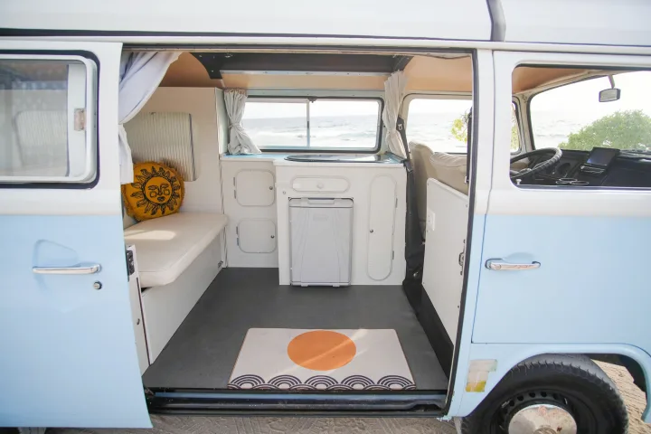 RV rental: Light blue camper van interior with kitchen, bench seating, and stunning ocean views. Ready for adventure!. Volkswagen T2 Westfalia 1976
