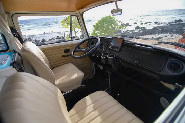 Relax in our RV rental! Inside view of a classic camper van's clean interior, parked seaside with a stunning ocean vista.. Volkswagen T2 Westfalia 1976
