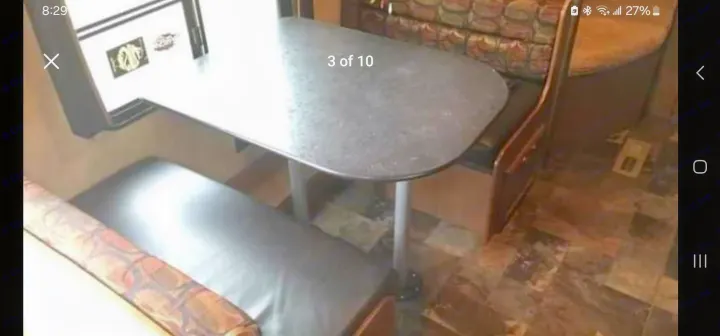 RV rental dinette: speckled gray table with central leg, cushioned booth seating. Ideal for meals on the go.. StarCraft autumn ridge 2014