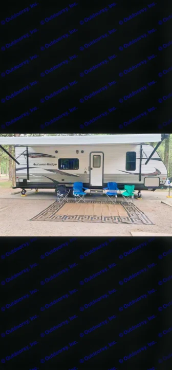 An Autumn Ridge RV rental is parked on gravel with an extended awning, four camping chairs, and a large outdoor mat.. StarCraft autumn ridge 2014