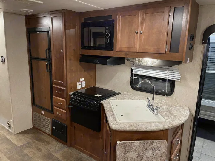 RV rental: inviting kitchen with warm wood cabinets, fridge, microwave, stove, sink, and spacious counter.. gulfstream Streamlite 2016