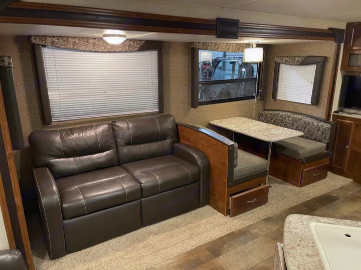 Spacious RV rental interior with comfortable leather sofa and dinette seating, perfect for mobile adventures.. gulfstream Streamlite 2016