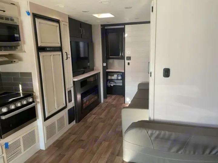 Spacious, modern RV rental interior with full kitchen, living area, fireplace, and comfy seating.. Entegra Coach Odyssey 2021