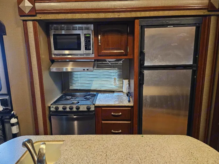 Compact RV rental kitchen: microwave, gas stove/oven, and fridge. All essentials for on-the-go living.. Keystone Outback 2016