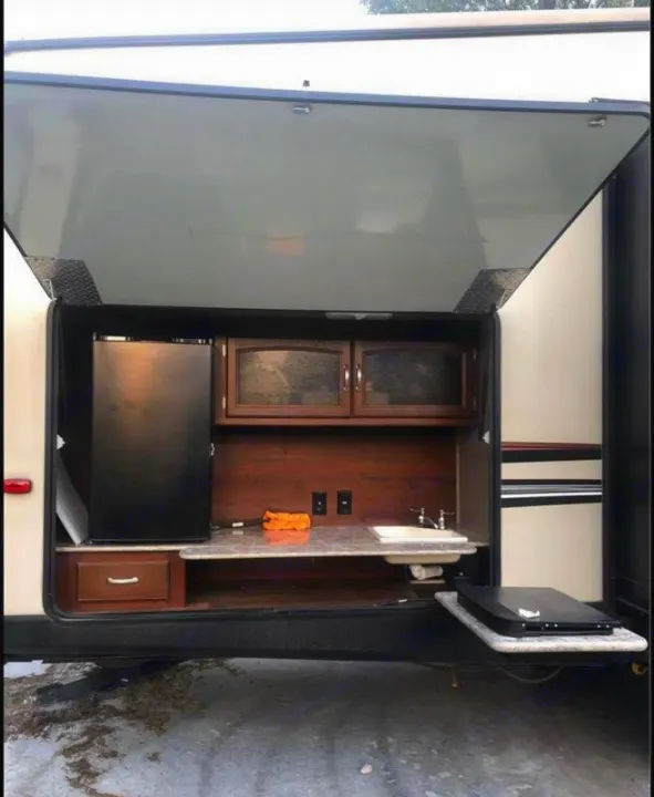 Spacious RV rental featuring an outdoor kitchen with fridge, sink, and cooktop – perfect for camping adventures!. Keystone Outback 2016