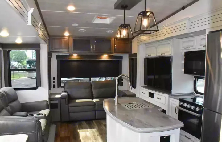 Inside a spacious RV rental: modern living area with recliner seating, full kitchen, and stylish finishes.. Keystone Cougar 2021