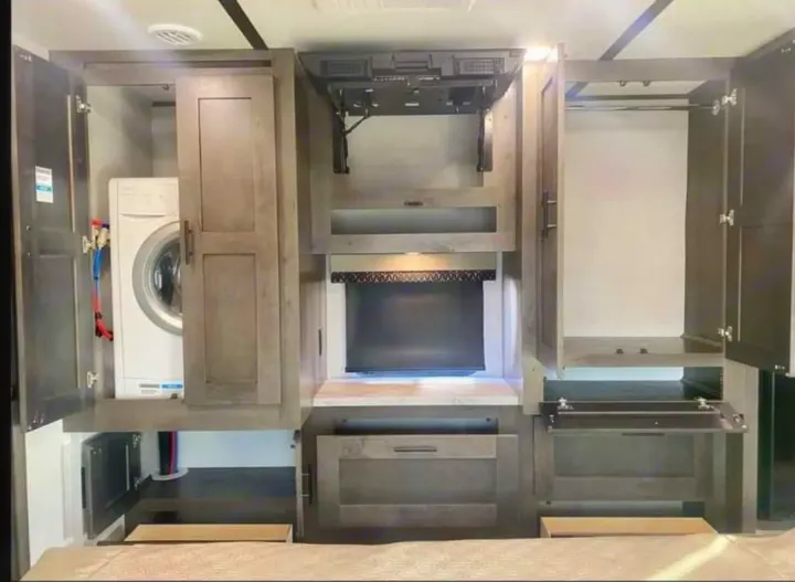 Efficient RV rental interior: compact laundry area with washer, central entertainment unit, and spacious wardrobe.. FR3 FR3 Motorhome 2023