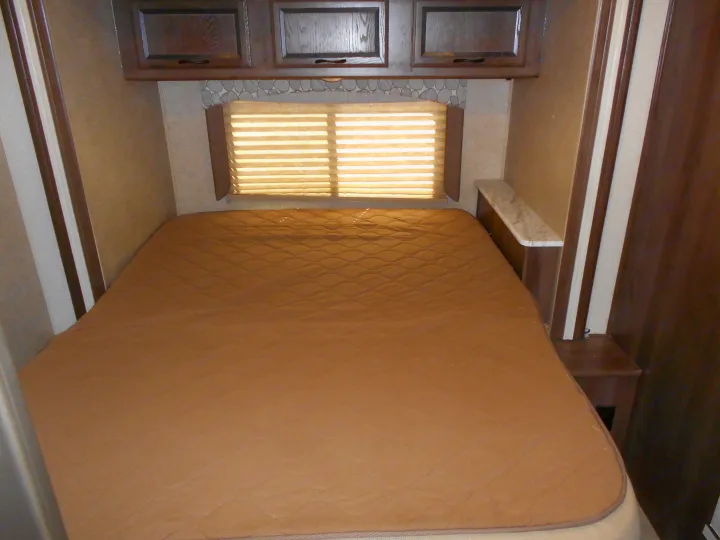 RV rental: Bedroom with a comfortable, quilted bed, overhead cabinets, and window with blinds.. Coachmen Freelander 2018