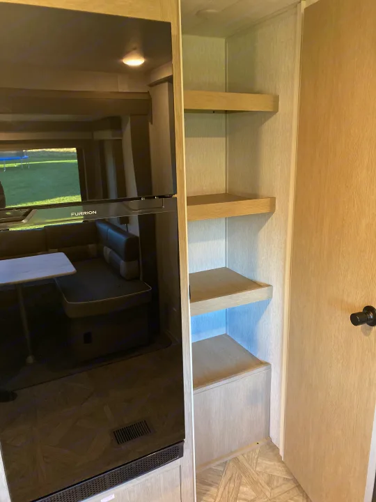 Modern RV rental: Furrion fridge, dinette, open shelving, light fixture, and patterned floor inside.. Forest River Salem 2024