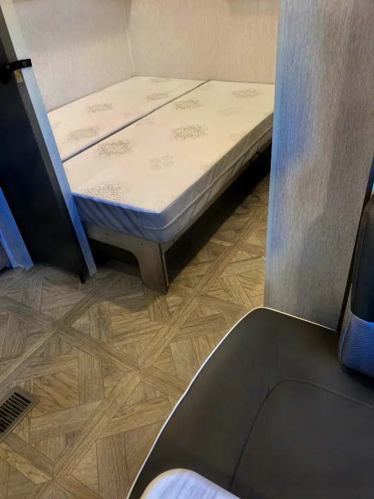 RV rental: Bright camper interior featuring twin beds, wood-look flooring, and textured wall panels.. Forest River Salem 2024