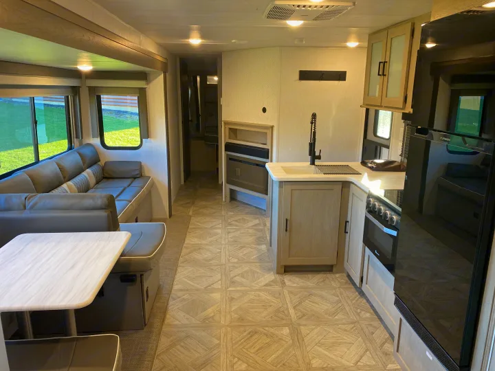 Bright, modern RV rental interior featuring a cozy living area, dining table, and a well-equipped kitchen.. Forest River Salem 2024