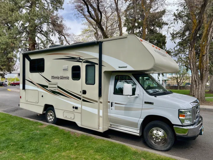 Cream Winnebago Minnie Winnie Class C RV parked roadside, ideal for your next rv rental adventure.. Winnebago Minnie Winnie 2017