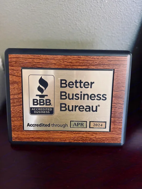A brown and silver Better Business Bureau plaque for an RV rental business, accredited through April 2024.. Thor Motor Coach Challenger 2019
