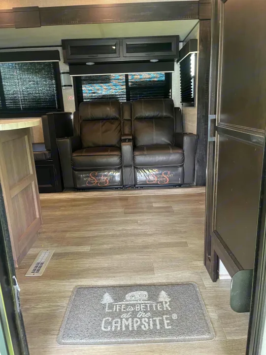 Step inside this inviting RV rental: a modern interior with comfy recliners and a fun 'campsite' mat.. Jayco Jay Flight 2022
