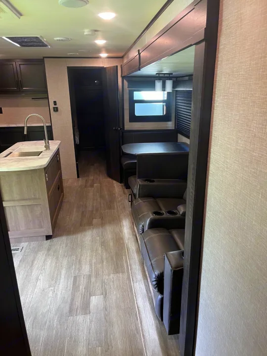 Spacious RV rental interior, showcasing a modern kitchen island, comfortable dinette, and reclining living area seats.. Jayco Jay Flight 2022