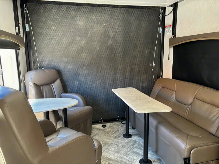 Comfortable RV rental interior with recliners, sofa, and dining tables, perfect for relaxing on your trip.. Forest River Stealth 2022