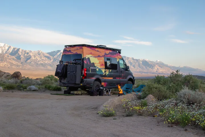 This colorful RV rental is perfectly set up for a desert camping adventure with a fire pit and mountain views.. Mercedes-Benz Sprinter 2023