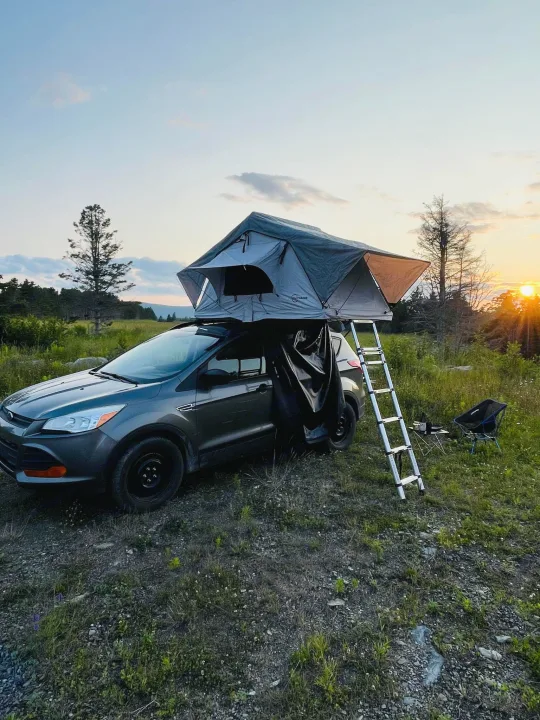 Car camping sunset with a deployed rooftop tent & ladder. A compact RV rental alternative for nature escapes.. Ford Escaper 2013