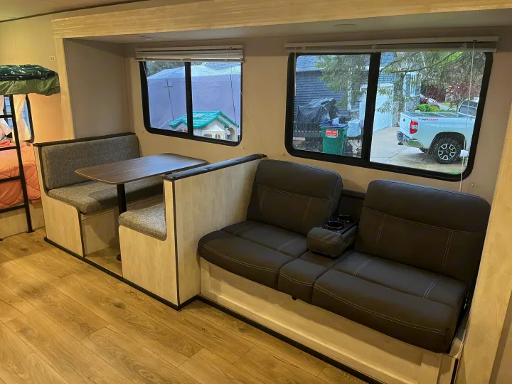 This RV rental features an interior with bunk beds, a dinette, and sofa seating, perfect for a family trip.. Shasta RVs I5 526DB 2024