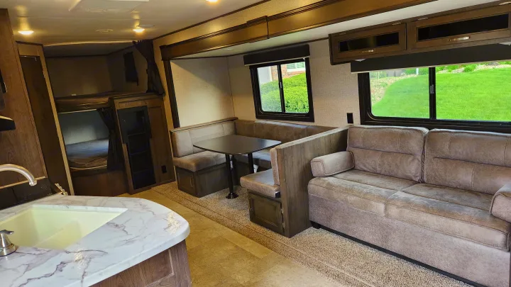 Spacious RV rental interior featuring a cozy living area, dinette, kitchen, and bunk beds. Perfect for family adventures!. Jayco Jay Flight 2021